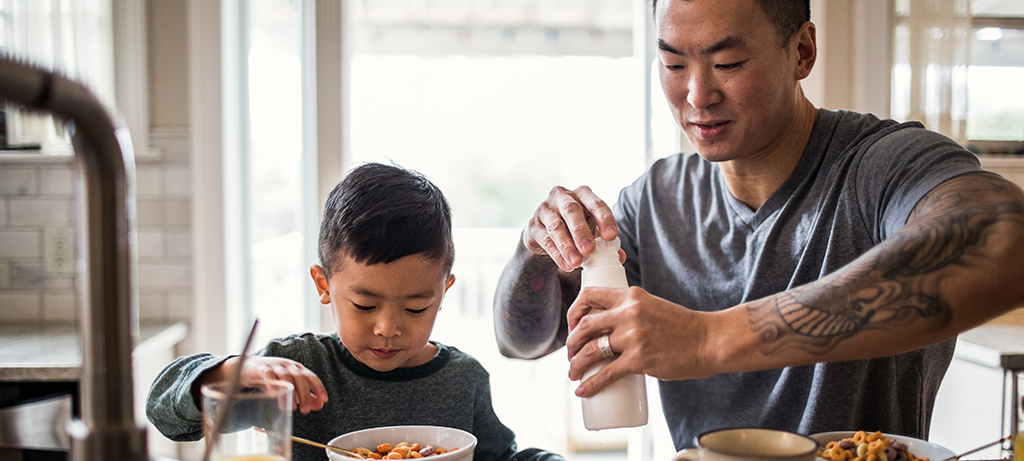 Father and son with milk and cereal
